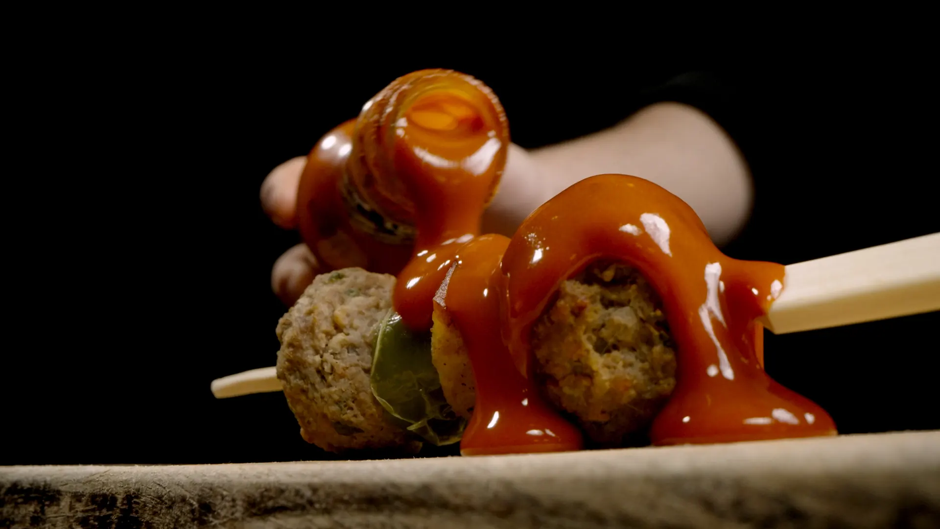 Sauce läuft über frittierte Happen auf einem Servierbrett